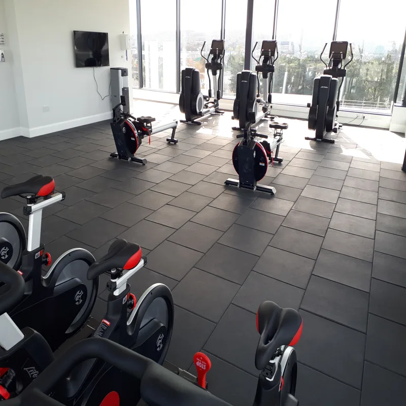 Spacious Dubai gym featuring black rubber floor.