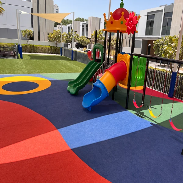 Modern EPDM rubber playground flooring with slides and swings.