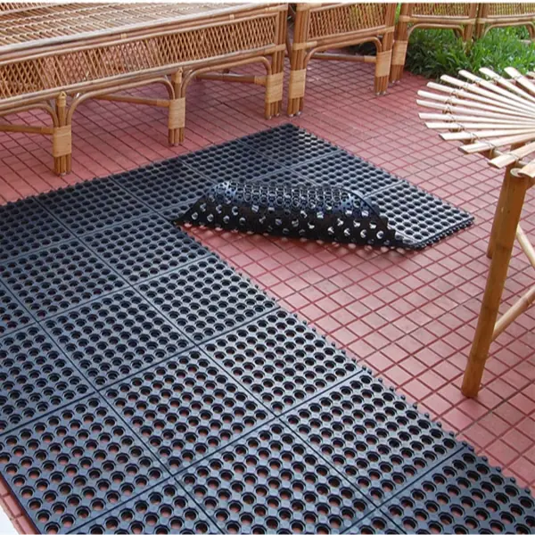 Black rubber hollow mats on a red tile patio.
