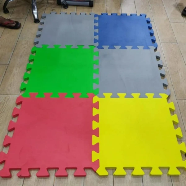 Colorful interlocking foam mats in a grid on a wooden floor