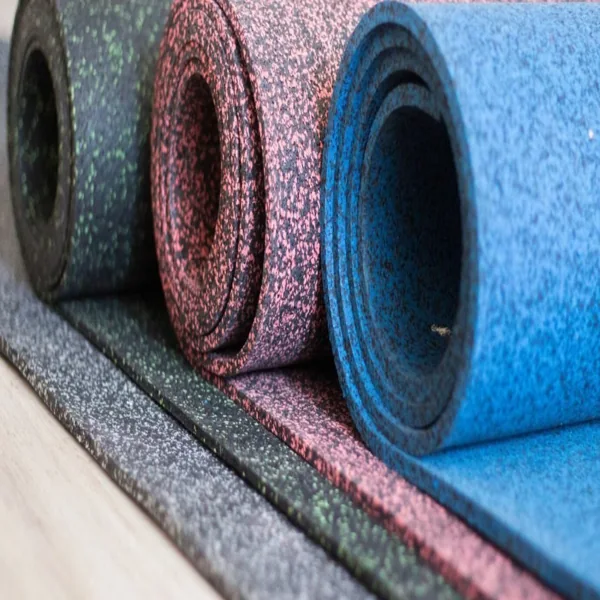 Three colorful speckled rubber flooring rolls lined up