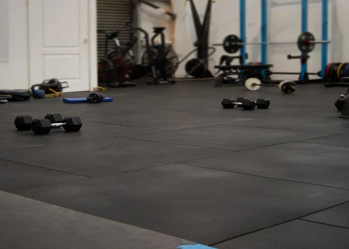 Black interlocking rubber floor tiles in a gym