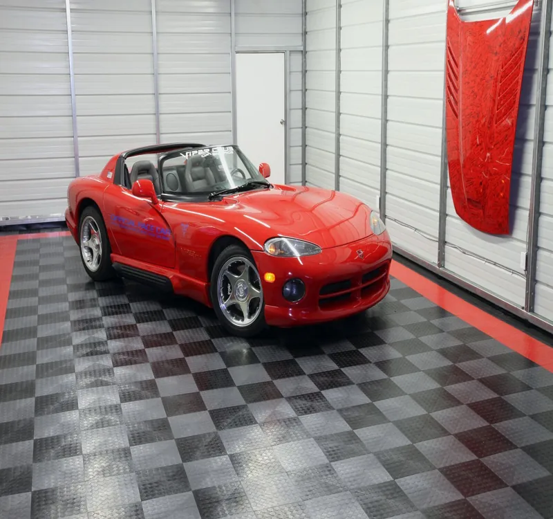 Red sports car on checkered garage floor tiles