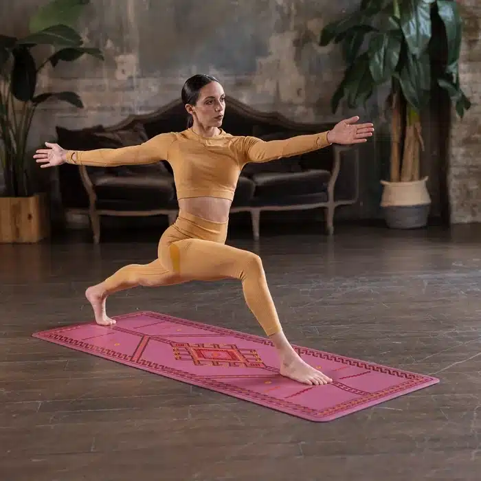 Woman doing yoga pose on pink mat
